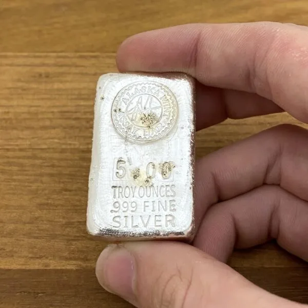 Hand-poured 5 oz silver bar held in hand — 5 troy ounces .999 fine silver, the size of a 5 oz bar at LBC Pawn Boston